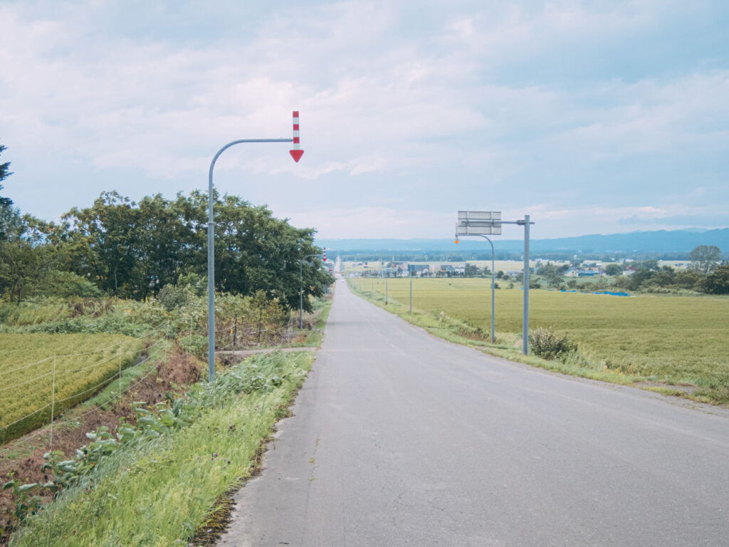 北海道の長い一直線の道路と矢羽根付きポール